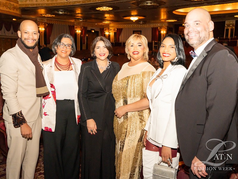 A group of six guests smiling together inside the event venue