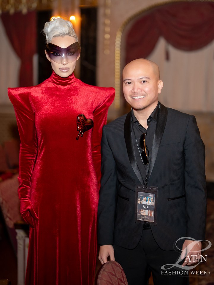 A red structured outfit photographed beside a guest at the event