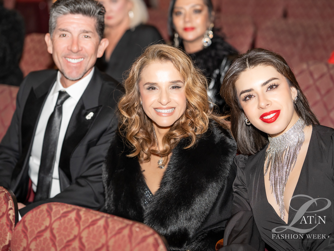Guests smiling together while seated in the audience at Latin Fashion Awards